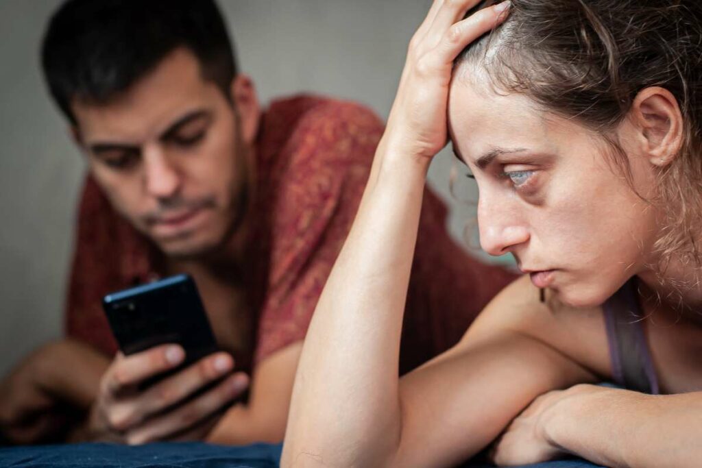 femme regardant homme sur telephone avec jalousie Femme ayant des soupçons sur son mari